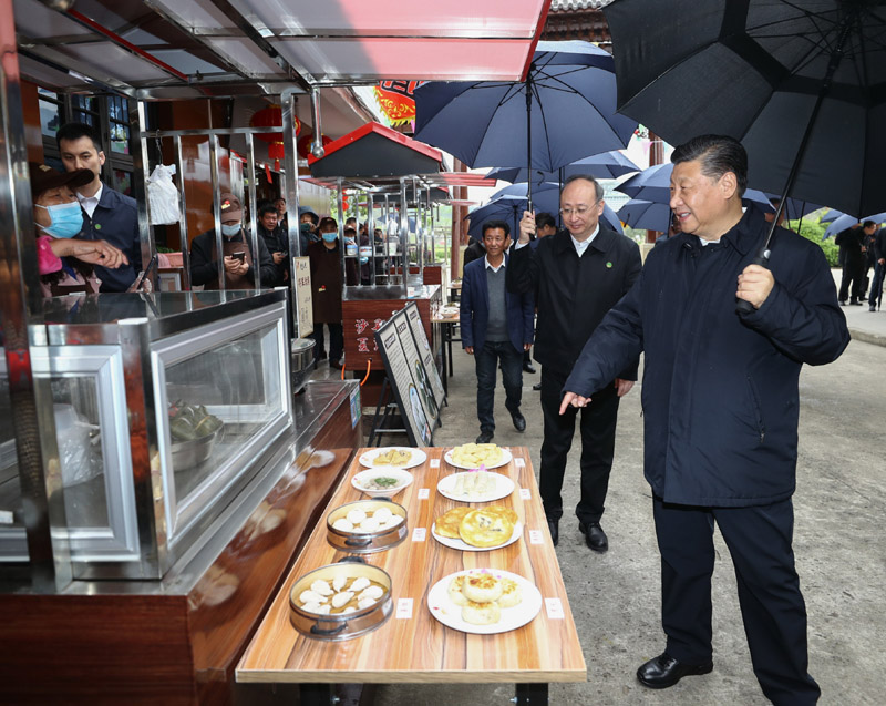 3月22日至25日，中共中央总书记、国家主席、中央军委主席习近平在福建考察。这是23日下午，习近平在三明沙县夏茂镇俞邦村考察时，在小吃摊边同乡亲们亲切交谈。新华社记者 鞠鹏 摄